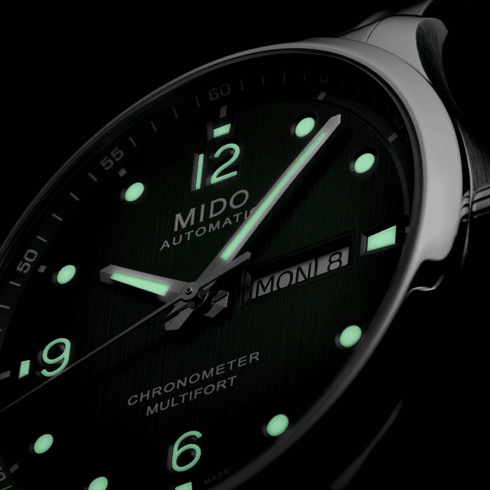 Orologio con quadrante verde scuro, indici luminescenti e data MON 8 visibile
