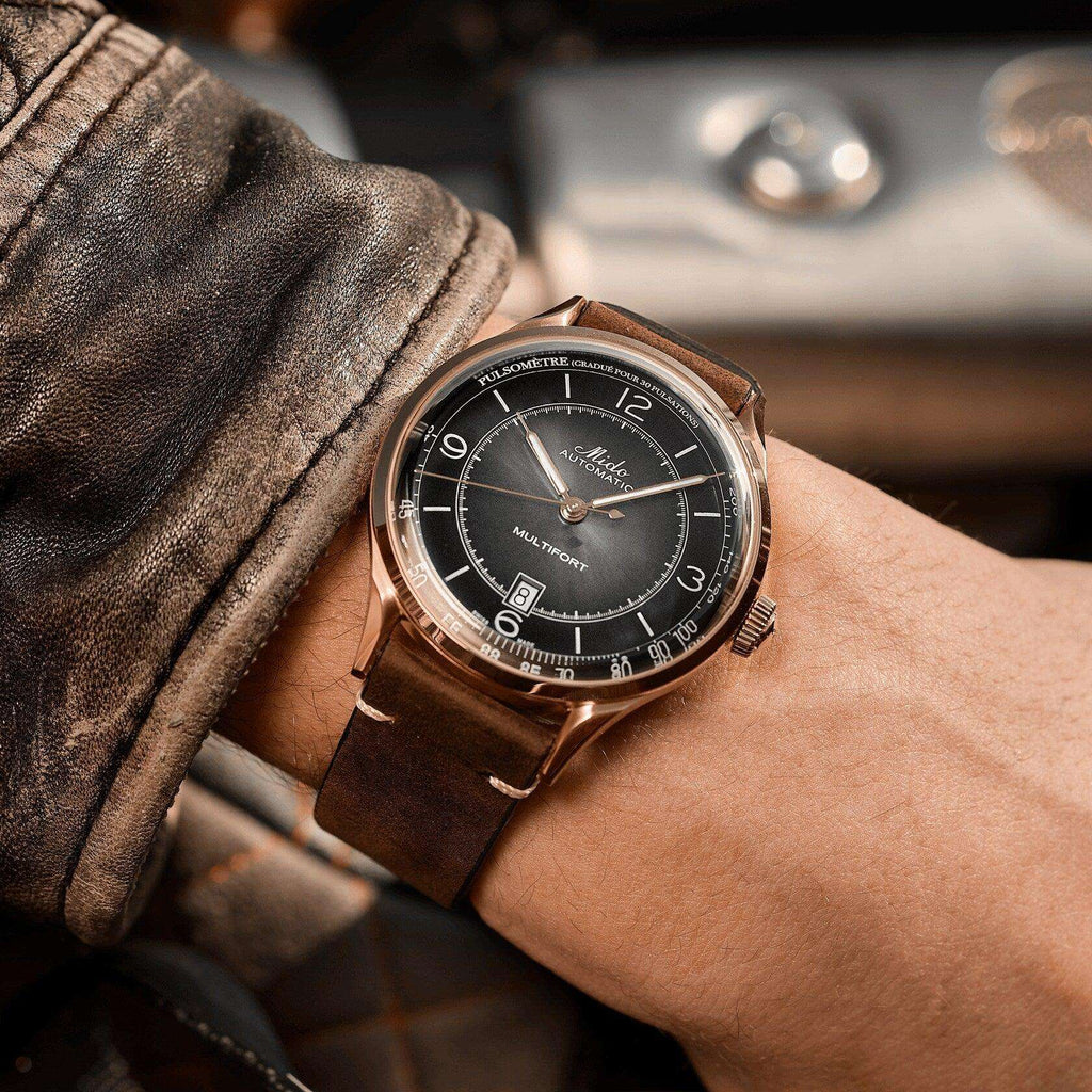Orologio automatico con quadrante nero, cassa rosé e cinturino in pelle marrone.