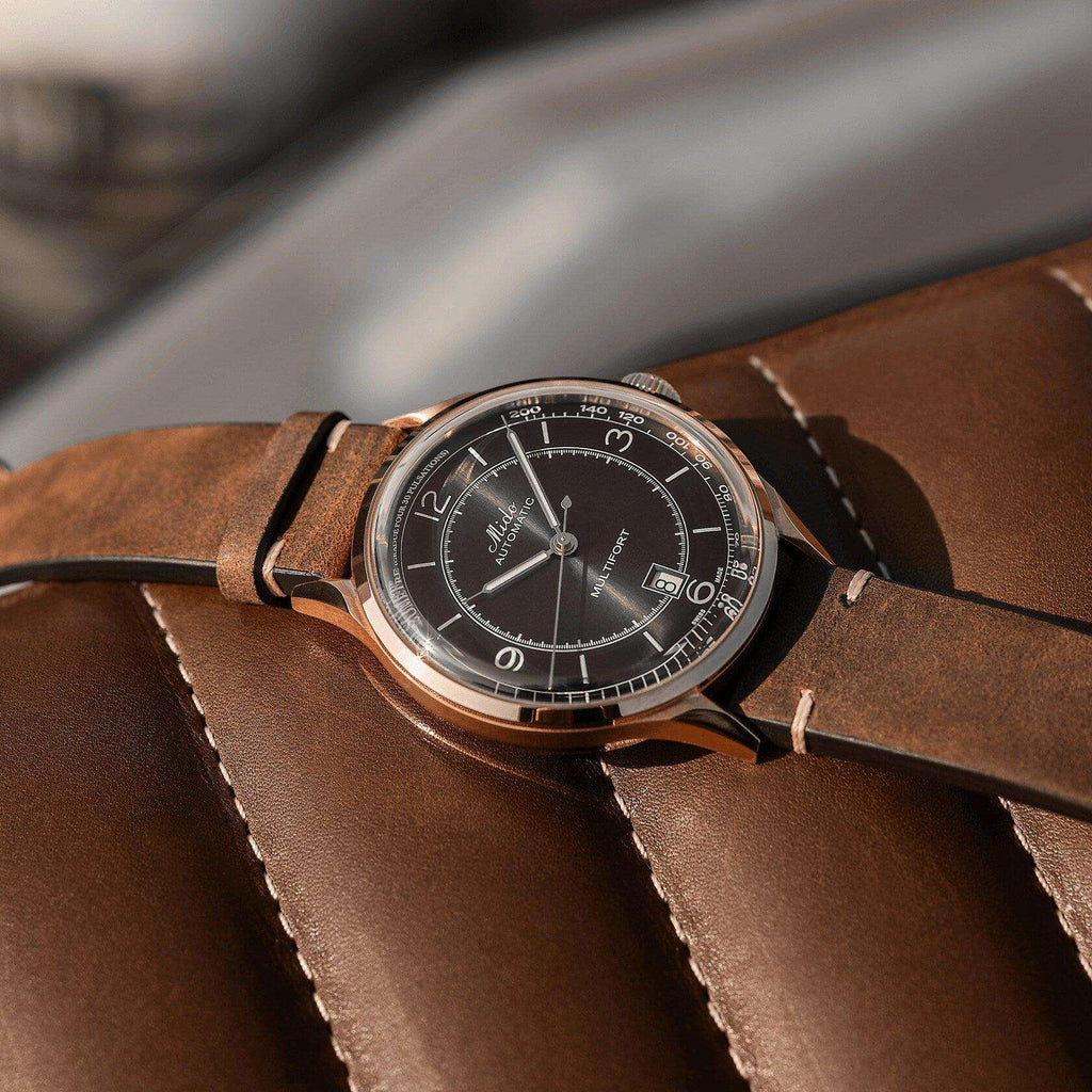Orologio automatico con quadrante nero, cassa rosé e cinturino in pelle marrone.