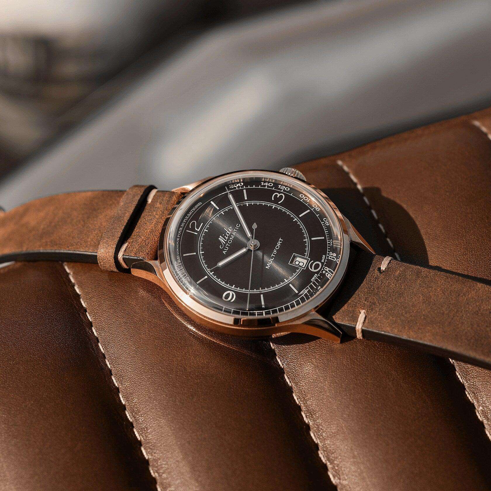 Orologio automatico con quadrante nero, cassa rosé e cinturino in pelle marrone.