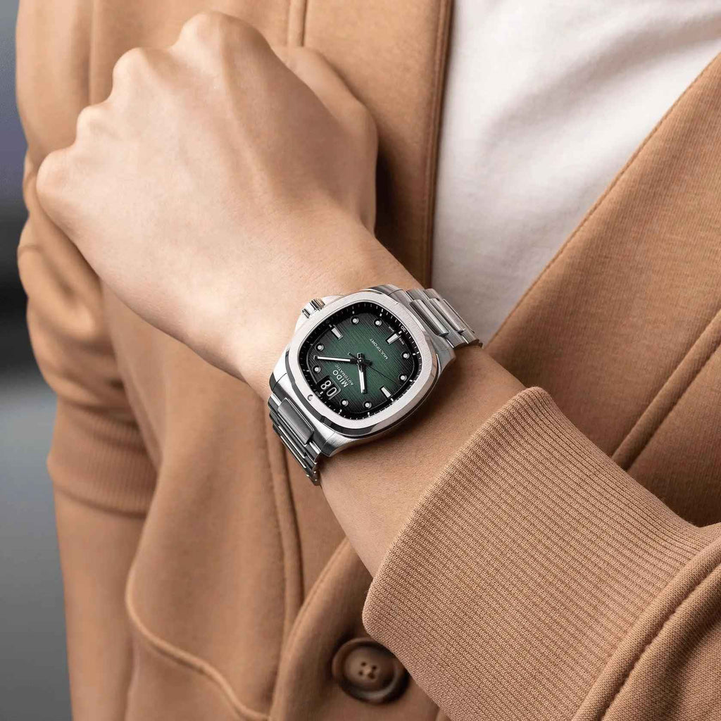 Orologio automatico con quadrante verde e bracciale in acciaio sul polso