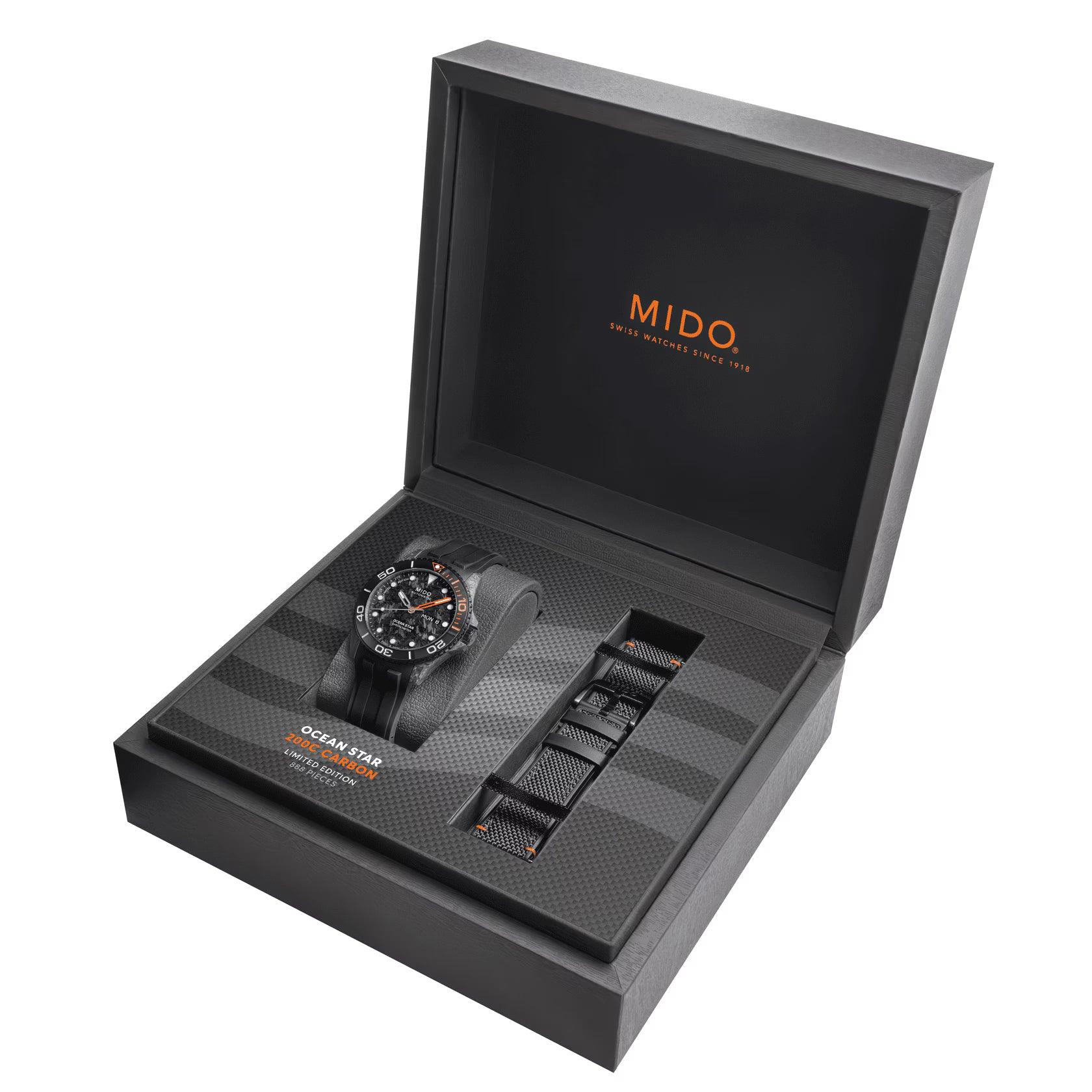 Orologio nero con scatola aperta e due cinturini, finitura in fibra di carbonio