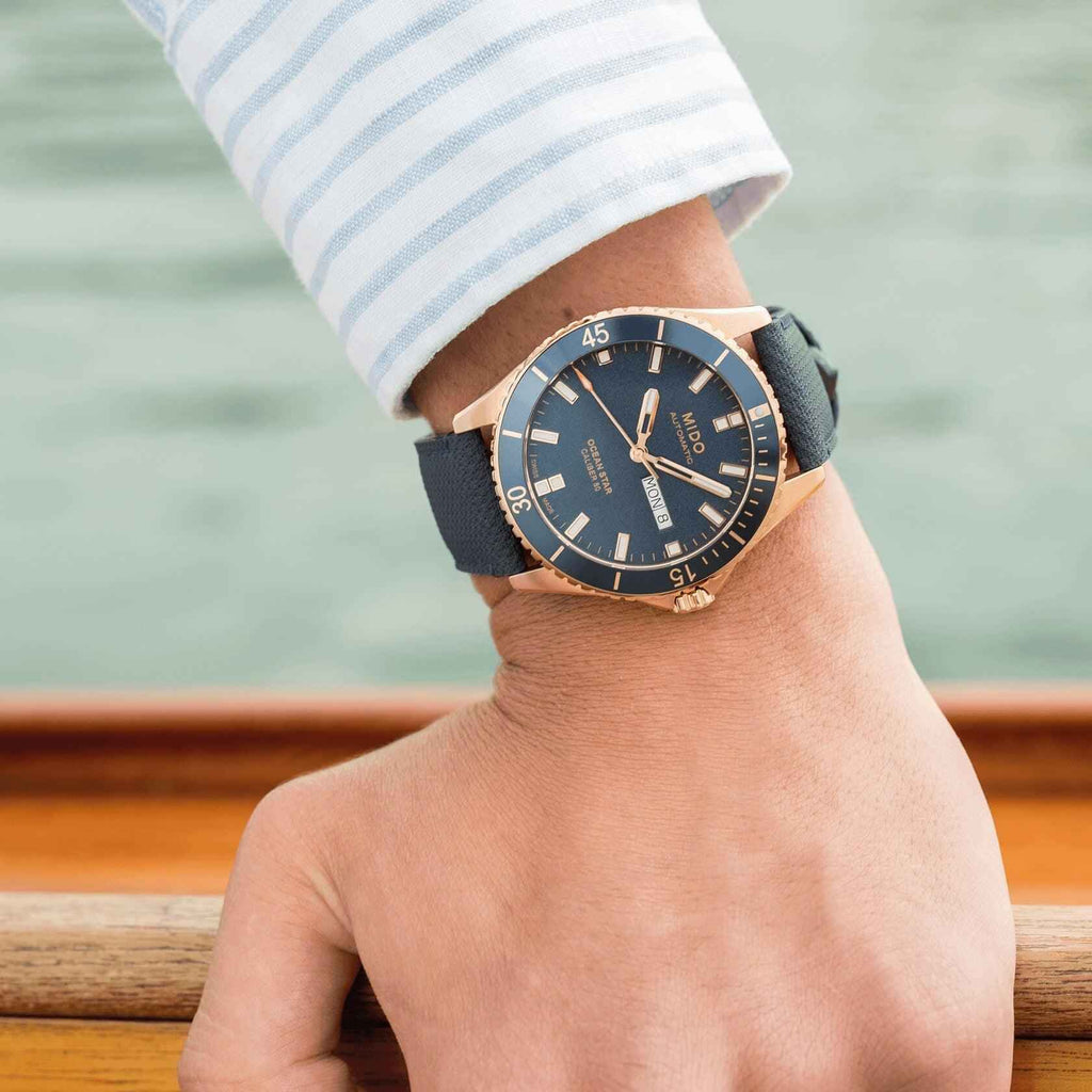 Orologio Mido Ocean Star su polso con cinturino blu e quadrante blu, lunetta PVD rosé
