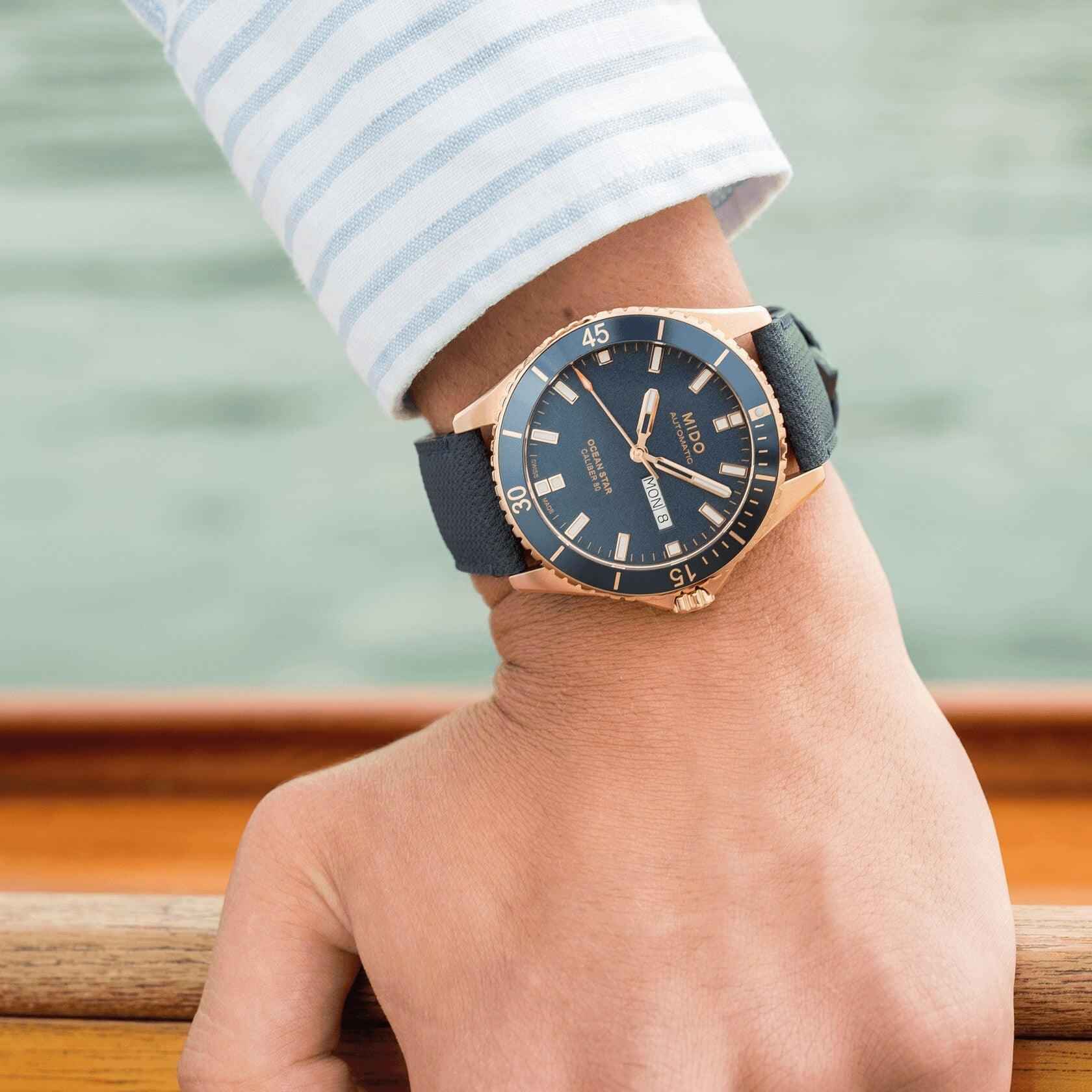 Orologio Mido Ocean Star su polso con cinturino blu e quadrante blu, lunetta PVD rosé