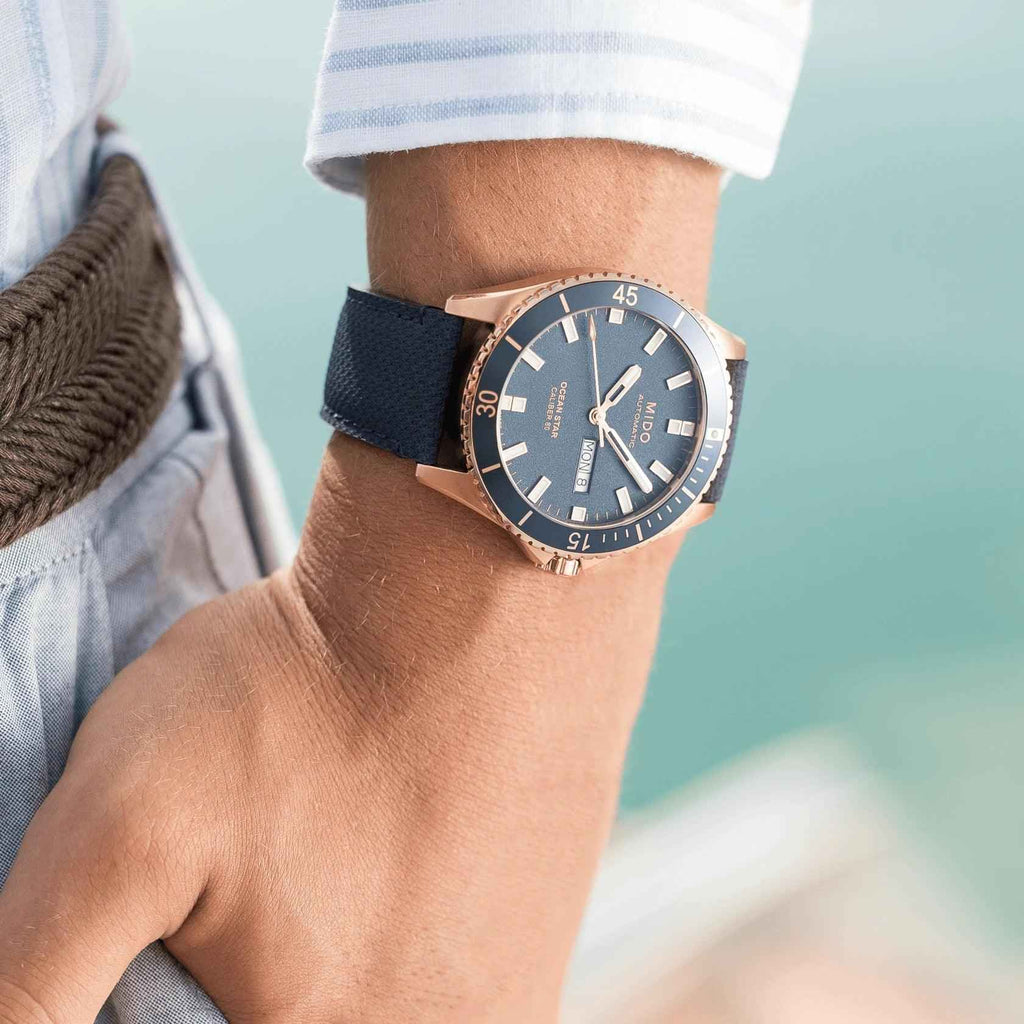 Orologio Mido Ocean Star su polso con quadrante blu e cinturino blu, lunetta rosé PVD