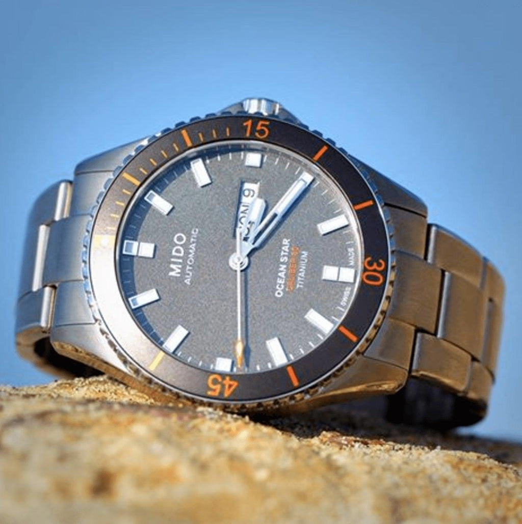 Orologio automatico Mido Ocean Star: quadrante nero, indici arancioni, bracciale grigio