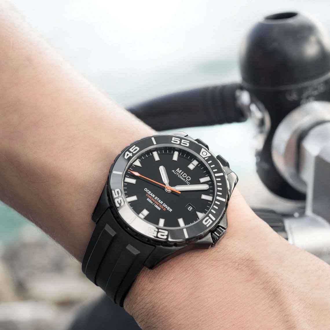 Orologio subacqueo Mido su polso con lunetta nera girevole e quadrante nero, datario