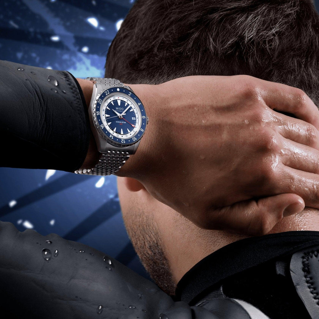 Orologio blu con bracciale a maglie indossato al polso