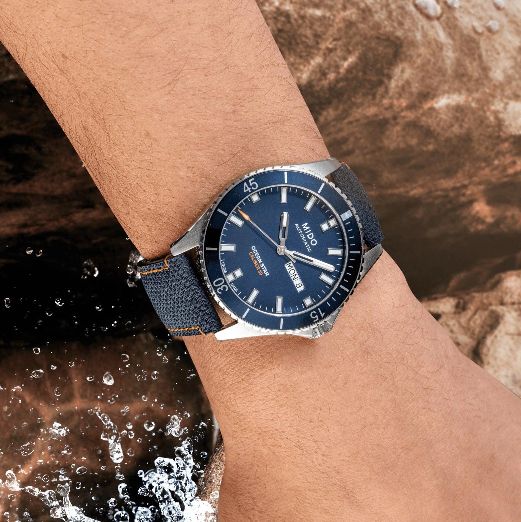 Orologio Mido con quadrante blu e cinturino blu testurizzato, indossato al polso