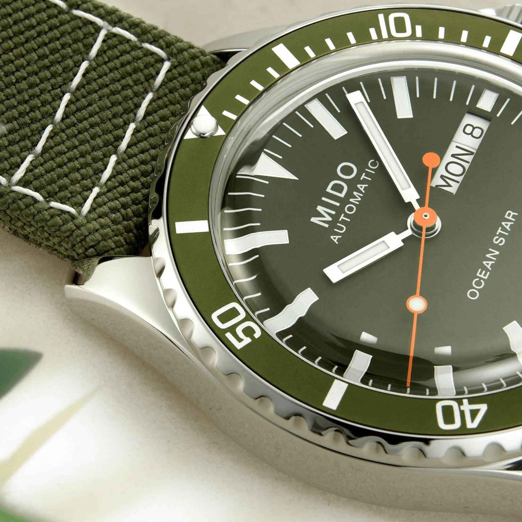 Quadrante verde Mido automatico con lancette arancioni e indici bianchi, lunetta nera