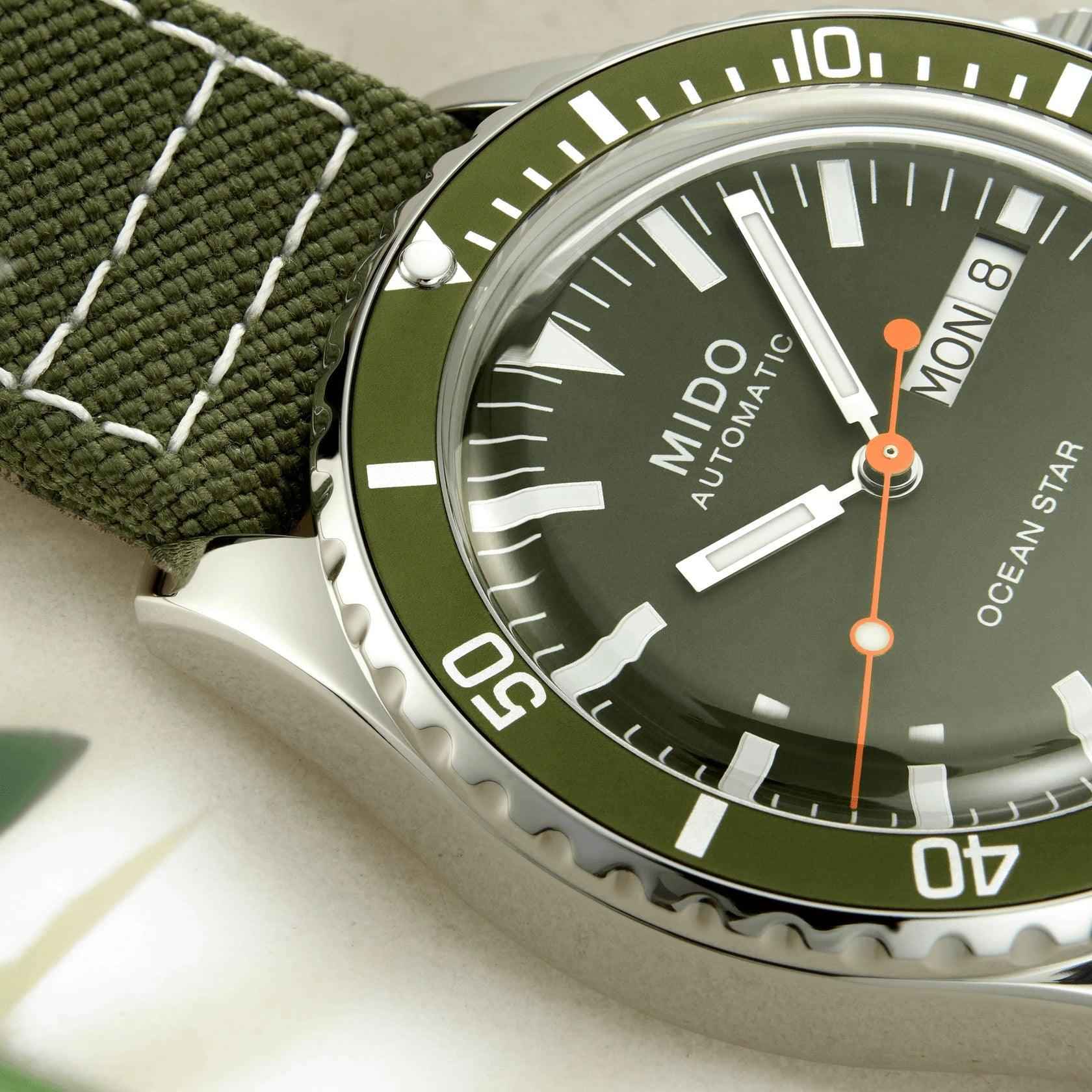 Quadrante verde Mido automatico con lancette arancioni e indici bianchi, lunetta nera