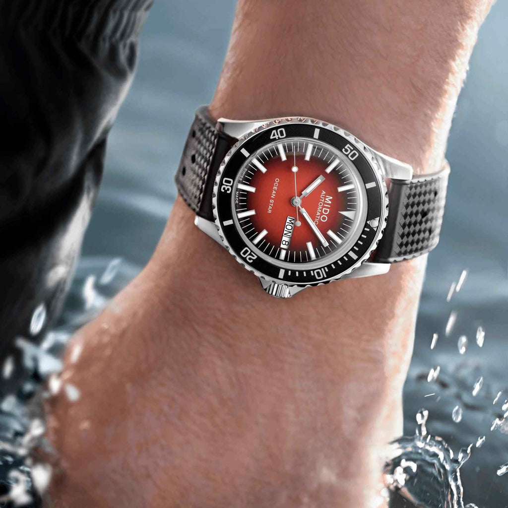 Orologio automatico al polso, quadrante rosso e cinturino nero, cassa d’acciaio