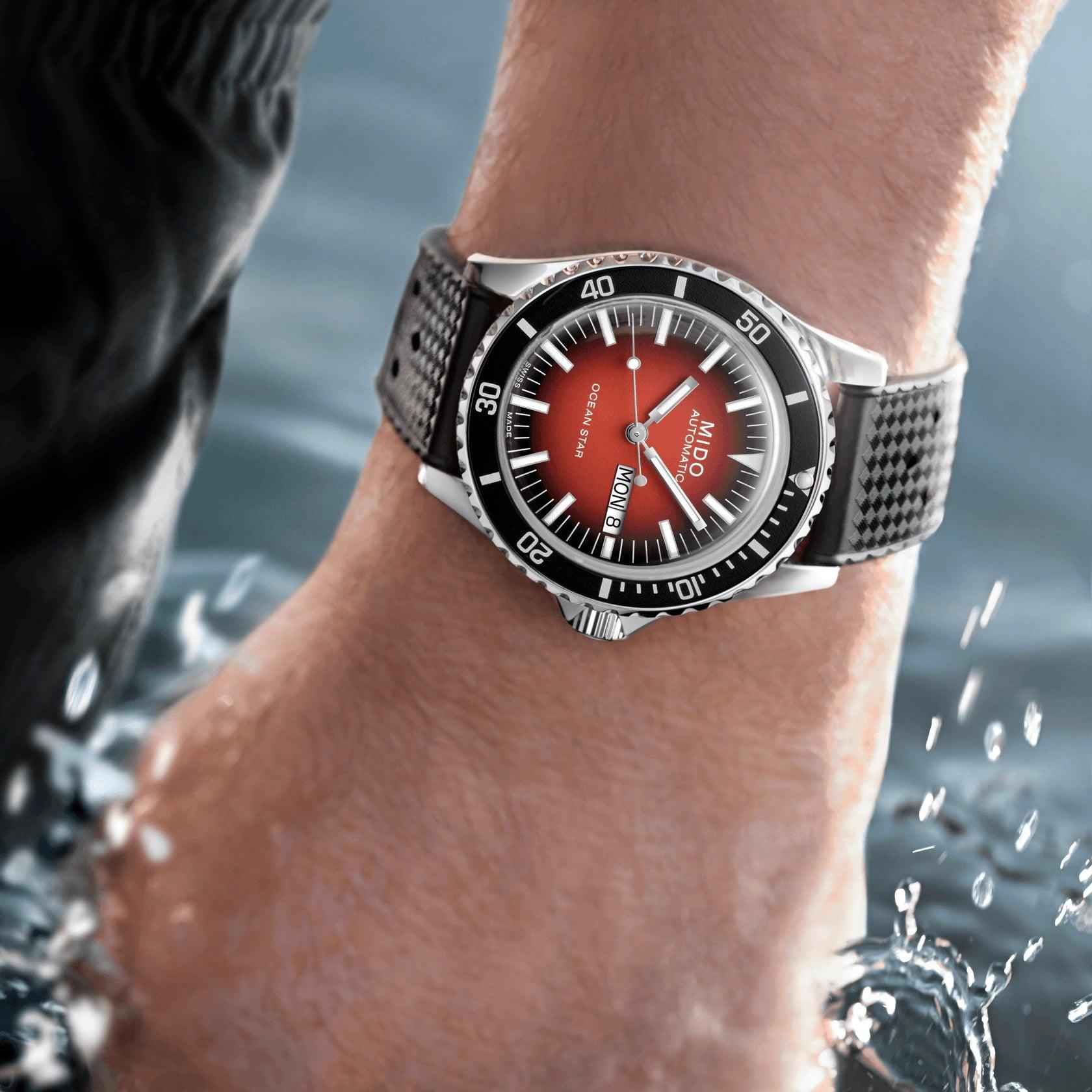 Orologio automatico al polso, quadrante rosso e cinturino nero, cassa d’acciaio