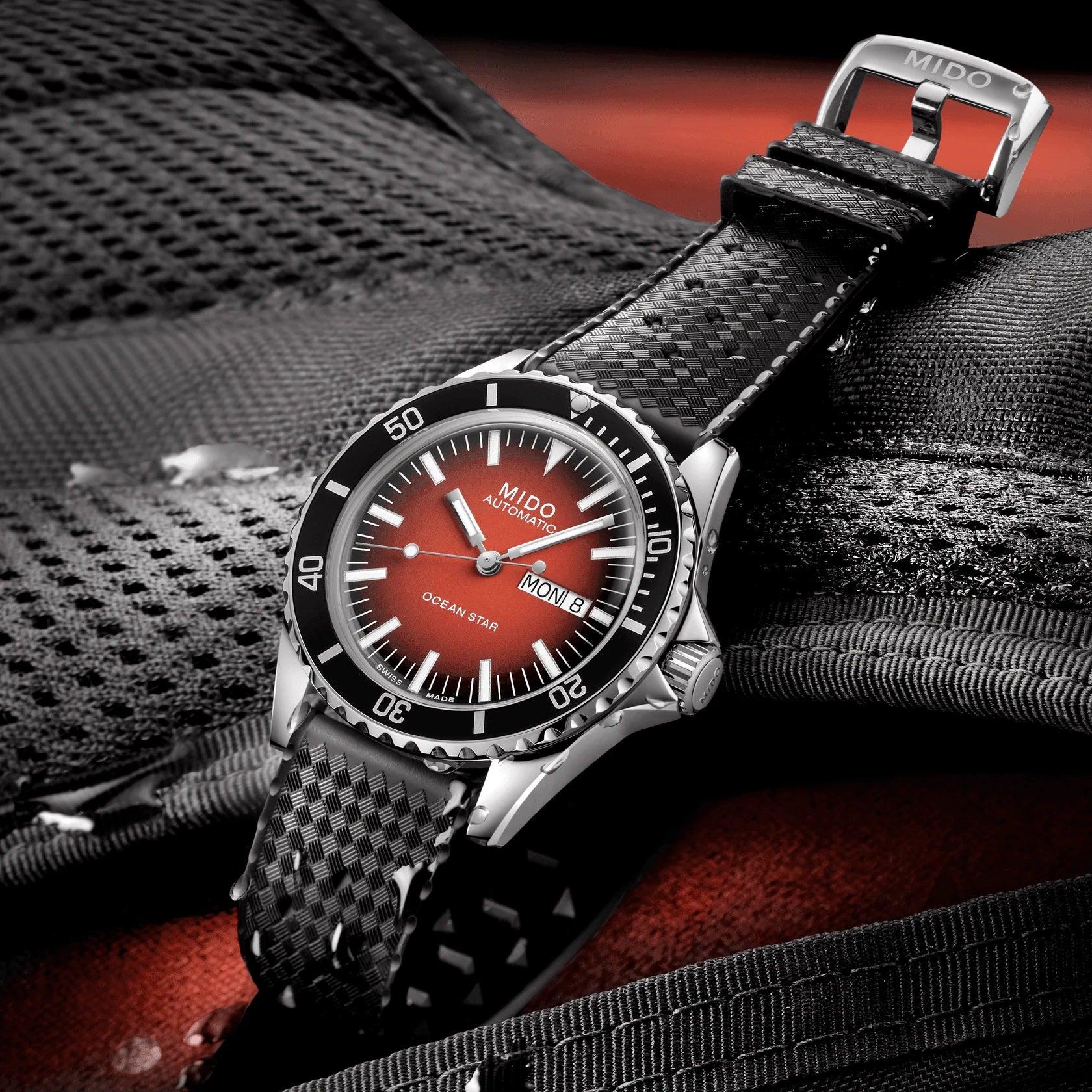 Orologio automatico con cassa acciaio e cinturino nero intrecciato, quadrante rosso