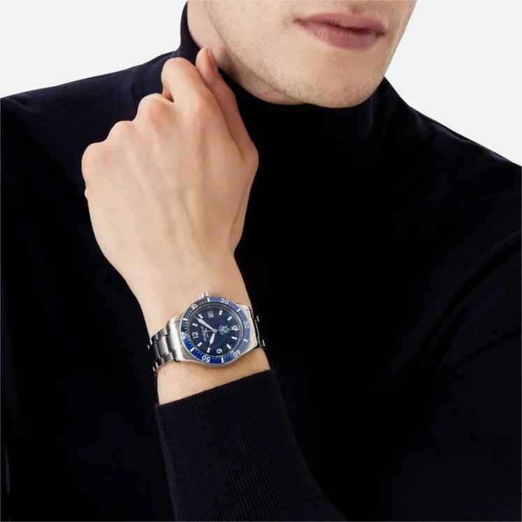 Orologio da polso al polso con quadrante blu e bracciale in acciaio, indossato
