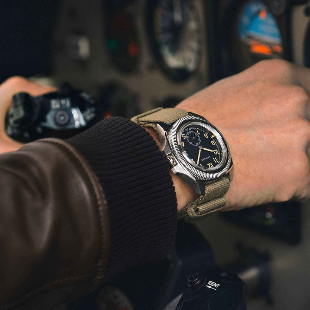 Orologio Longines su polso con quadrante nero e cinturino verde oliva.