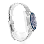 Orologio subacqueo con cassa d’acciaio e lunetta blu, bracciale in maglia, vista laterale.