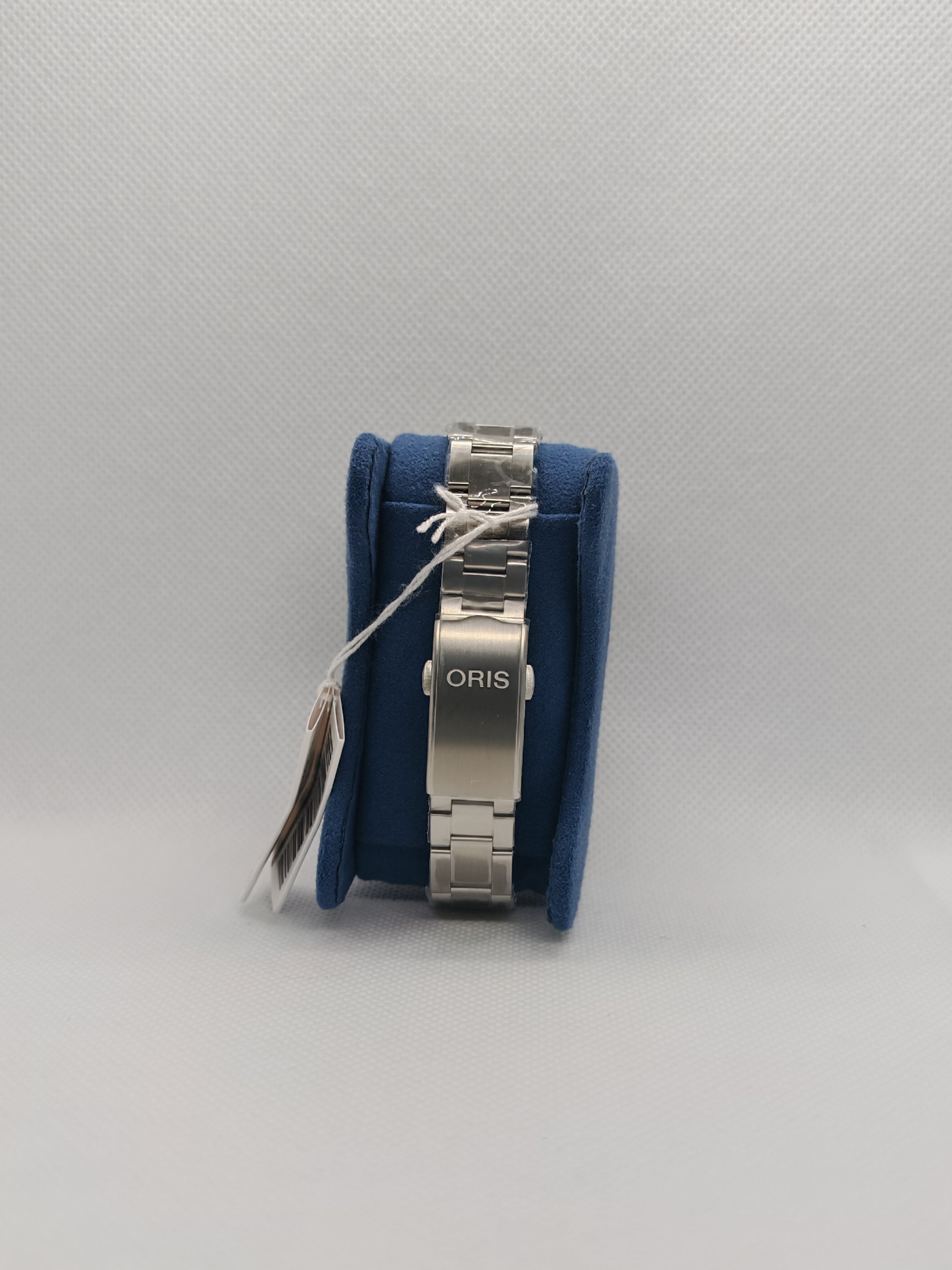 Orologio Oris su supporto blu con bracciale in acciaio
