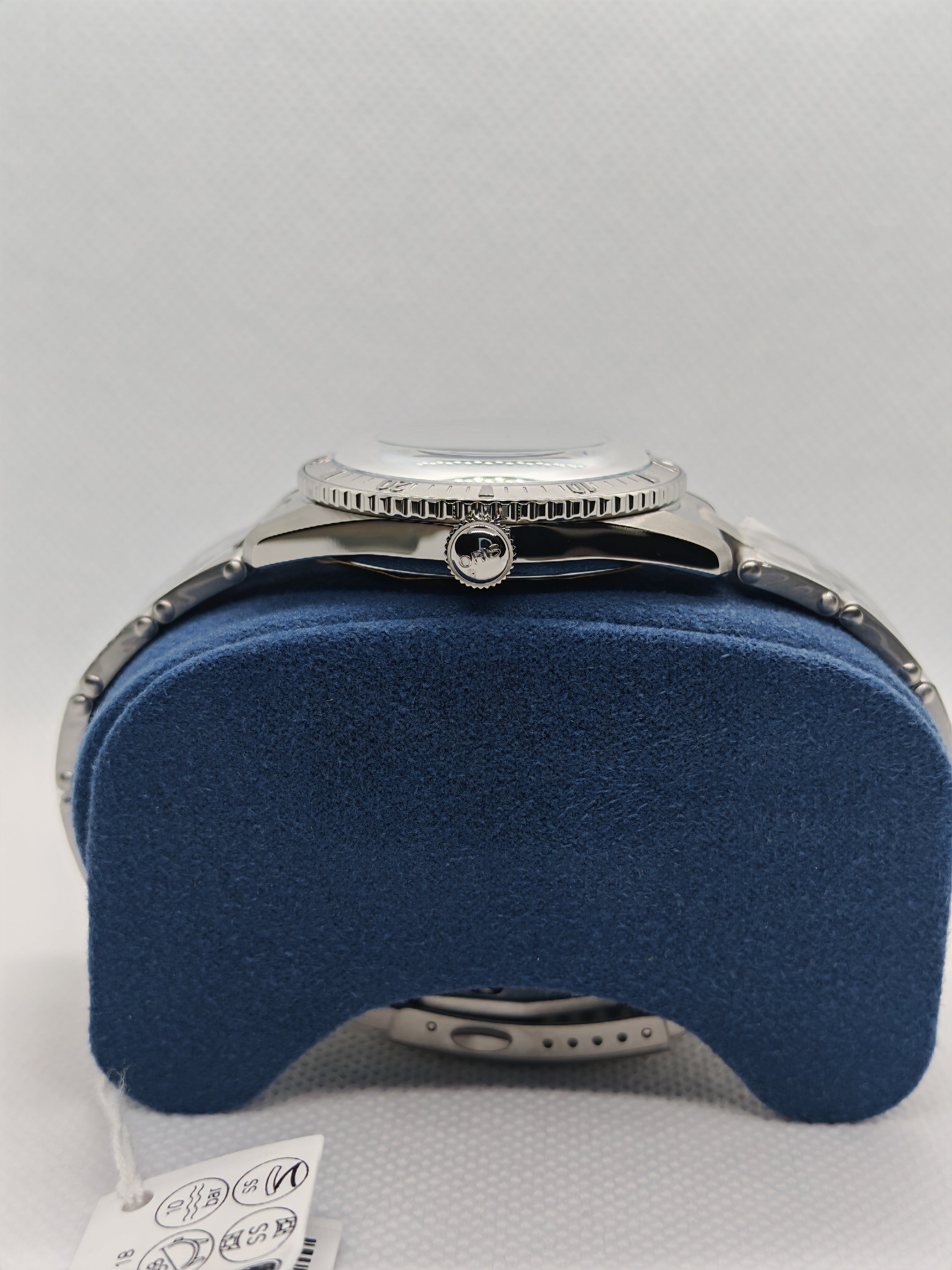 Orologio sub in acciaio con corona, quadrante coperto, fondo con logo, su supporto blu