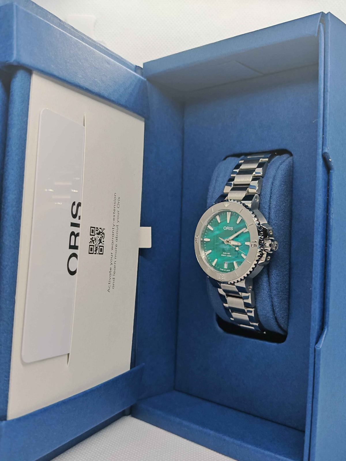 Orologio con quadrante verde e bracciale in acciaio nel cofanetto blu