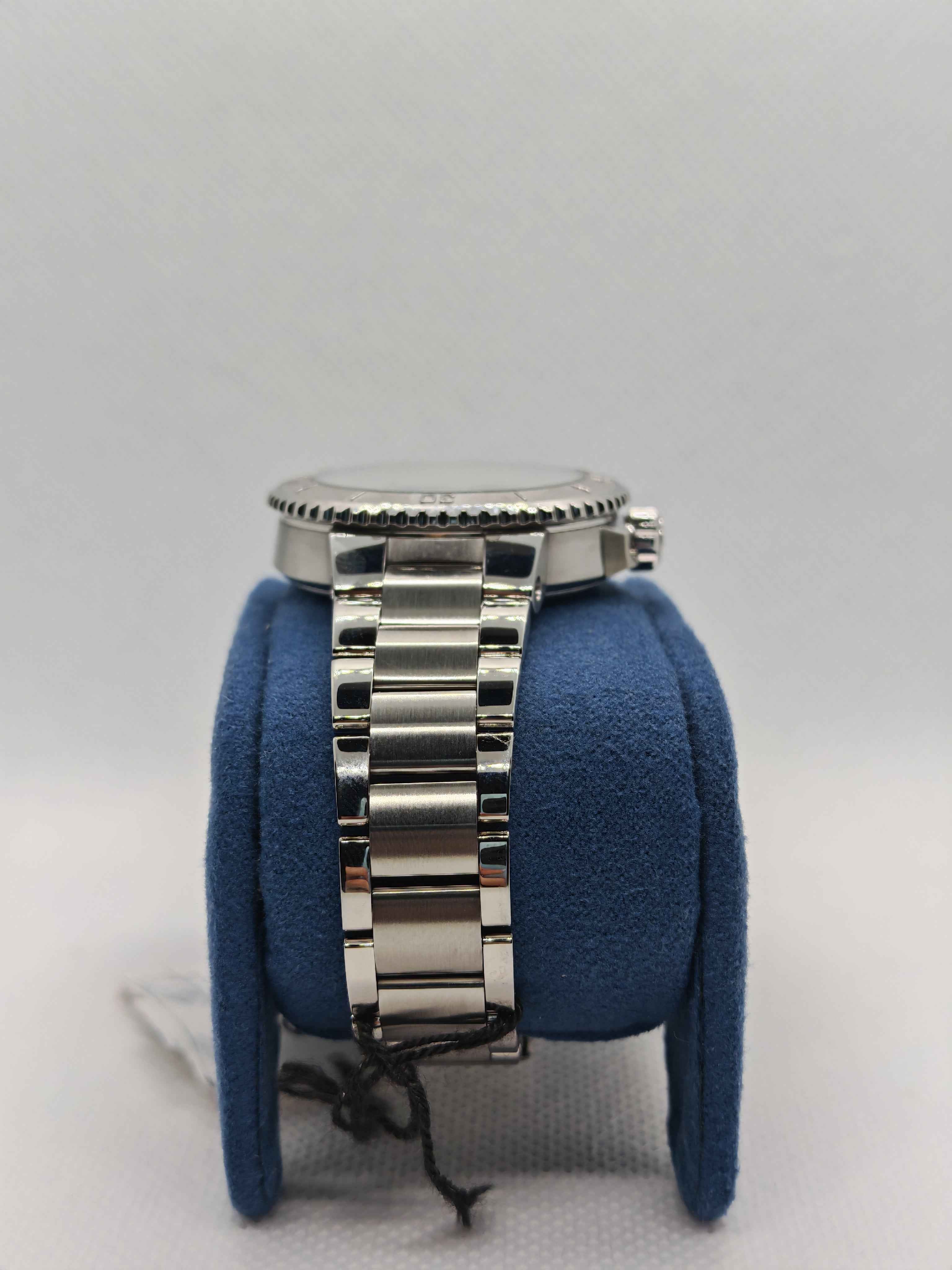 Bracciale orologio in acciaio con maglie lucidate, su supporto blu