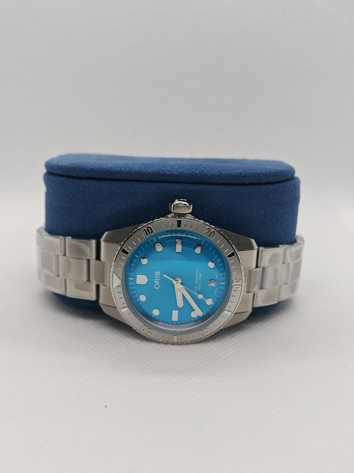 Orologio Oris con bracciale in acciaio e quadrante blu su supporto blu
