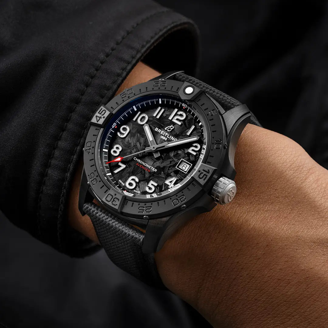 Orologio Breitling al polso: quadrante nero con indici bianchi e cinturino nero tessitura