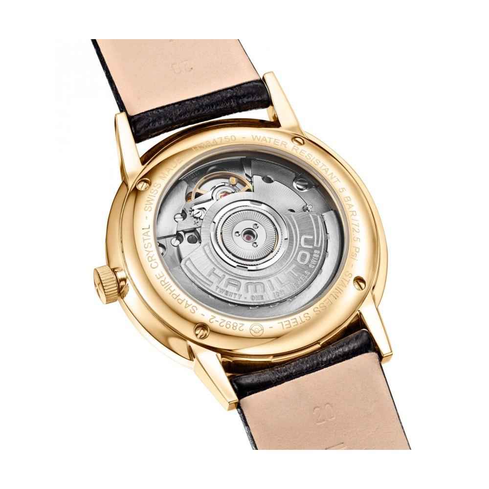 Fondello dell’orologio con movimento visibile, cassa dorata e cinturino in pelle nera