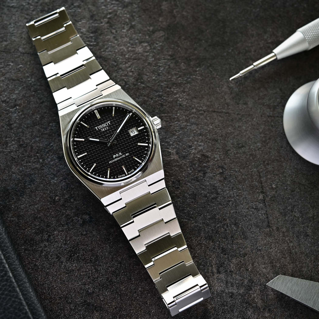 Orologio Tissot PRX con bracciale in acciaio e quadrante nero, dettagli logo