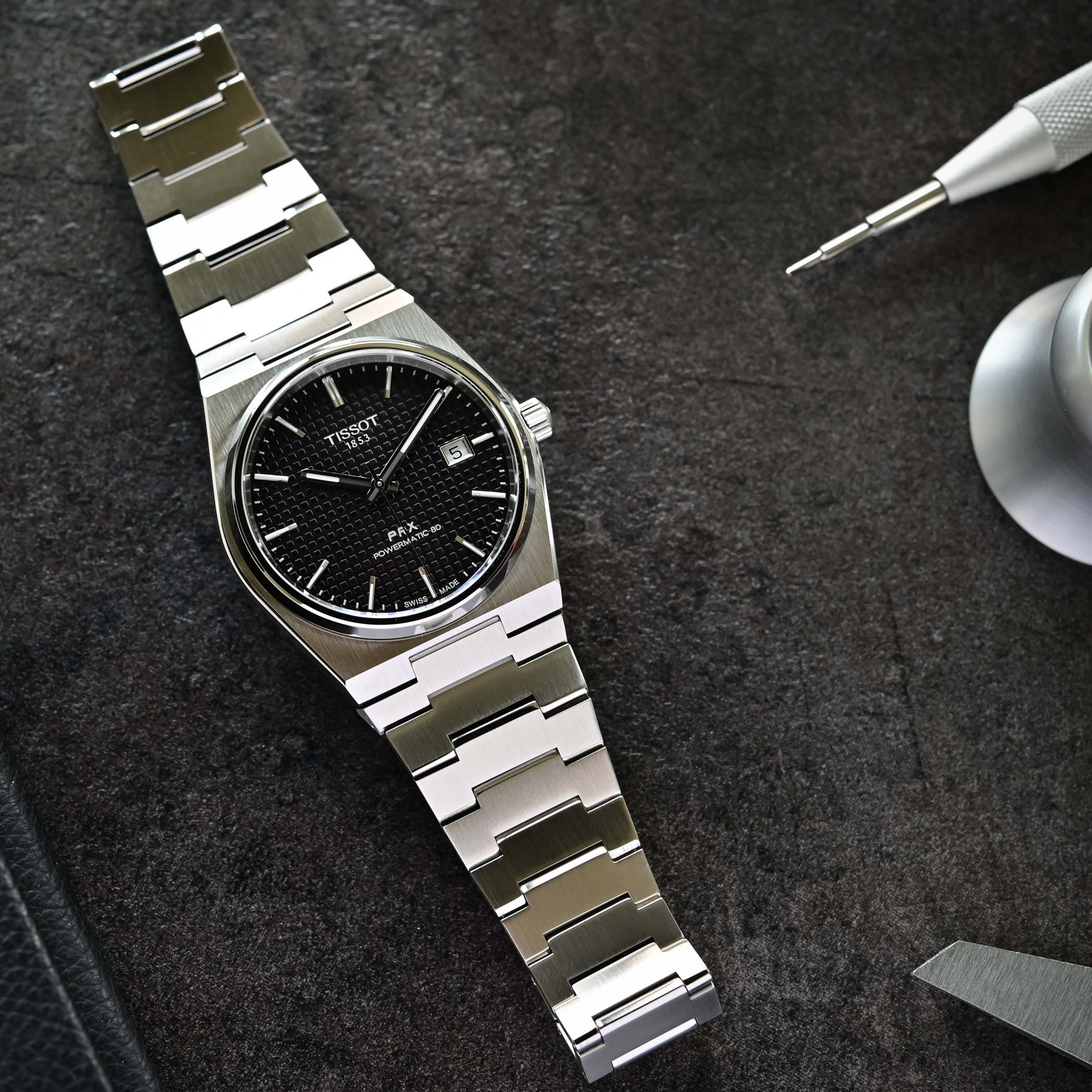 Orologio Tissot PRX con bracciale in acciaio e quadrante nero, dettagli logo