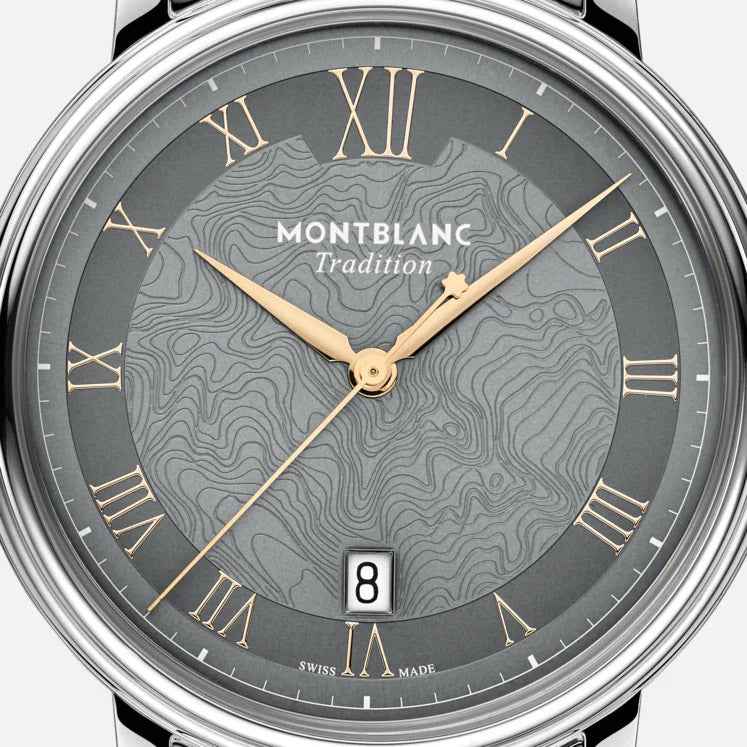 Quadrante grigio con numeri romani dorati, lancette dorate e data sul vetro dell’orologio.