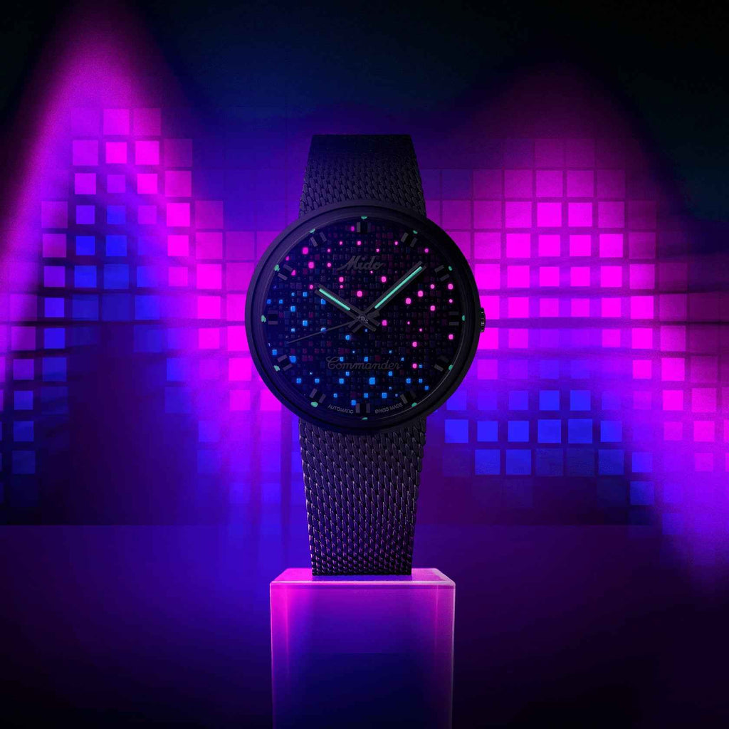 Orologio con quadrante nero e cinturino in maglia scura, cassa rotonda