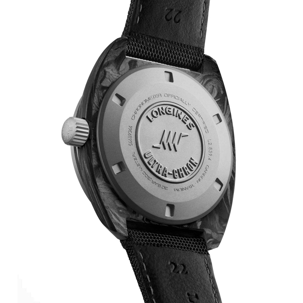 Orologio Longines Ultra‑Chron 43 mm: fondello con incisioni e cinturino nero in tessuto.