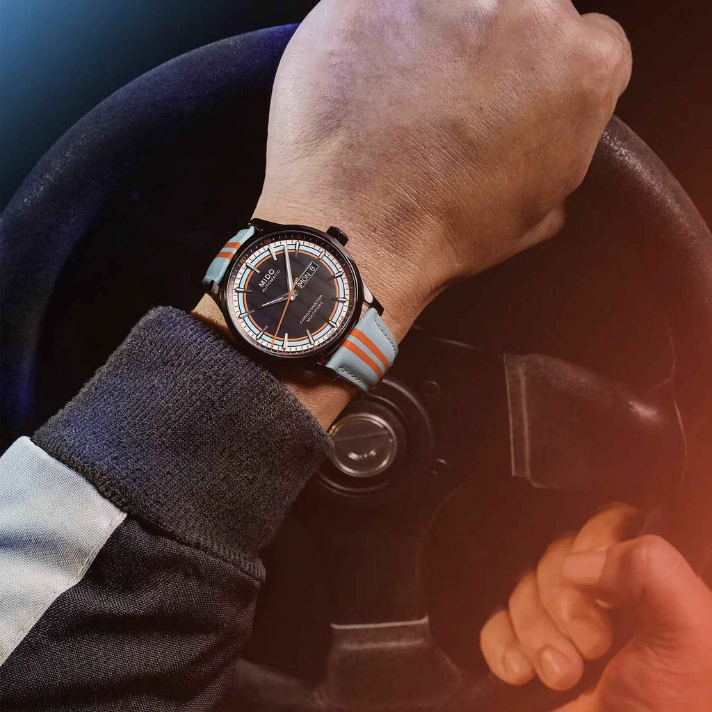 Orologio automatico con quadrante nero e cinturino azzurro a righe arancioni al polso