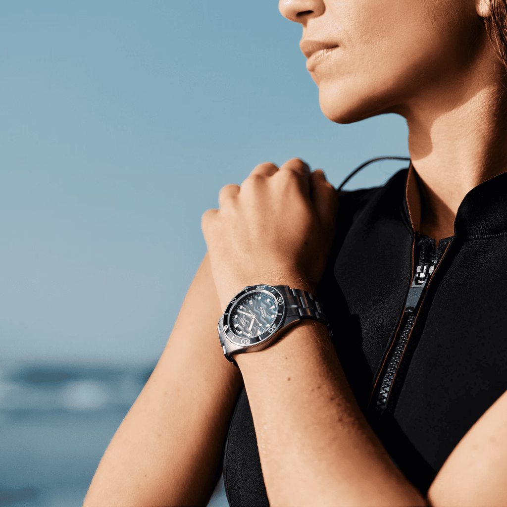 Orologio Mido con quadrante blu e bracciale in acciaio, indossato al polso.