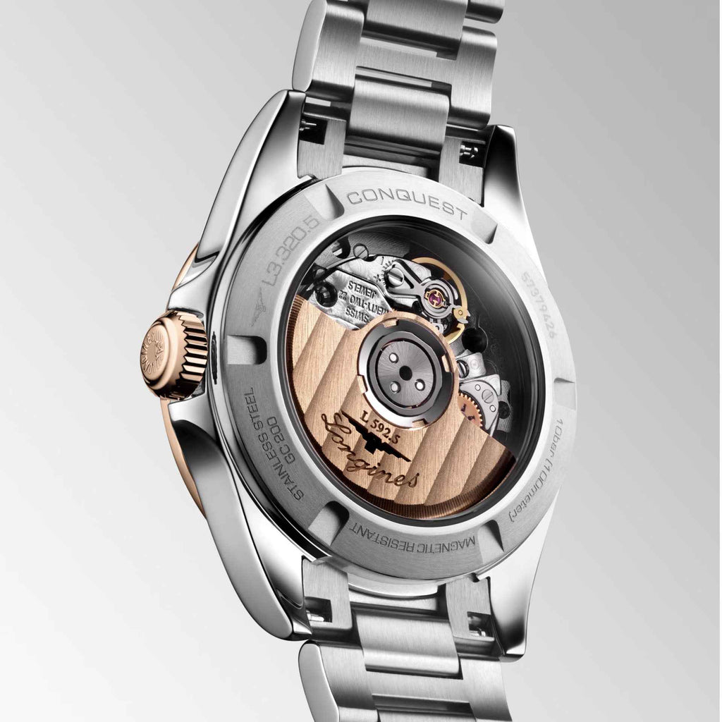 Vista laterale dell’orologio Conquest 30 mm con corona oro rosa e fondello a vista